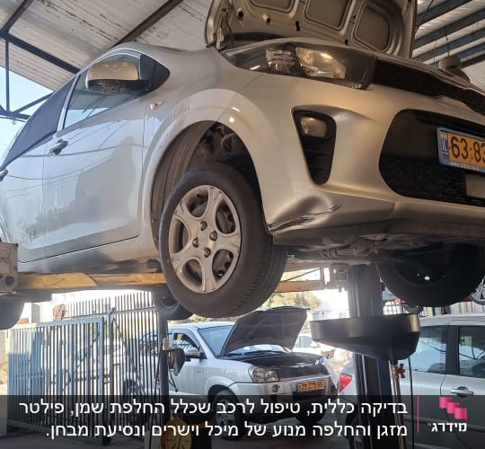 רכב מורם על ליפט במוסך עם מכסה מנוע פתוח